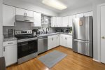 Modern kitchen appliances include an electric range & oversized fridge 